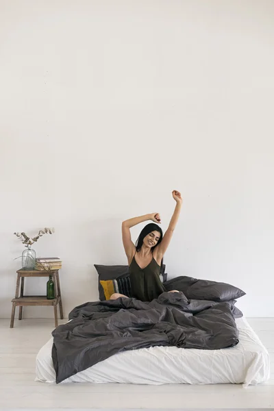 Ganska ung flicka stretching på sängen — Stockfoto