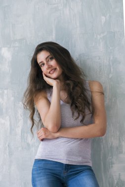 Güzel esmer kameraya bakarken yanağına elini tutarak