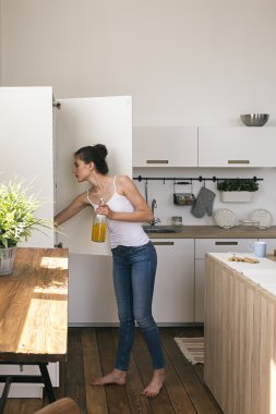 Buzdolabında bakarken şişe suyu tutan kadın yan görünüm
