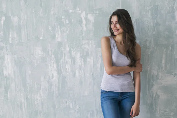 Beautiful smiling brunette embracing herself with one arm — Stock Photo, Image