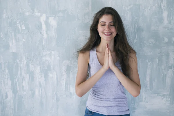 Glückliche Frau lächelt mit geschlossenen Augen und Händen in Namaste — Stockfoto
