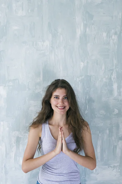 Mulher feliz com mãos namaste sorrindo para a câmera — Fotografia de Stock