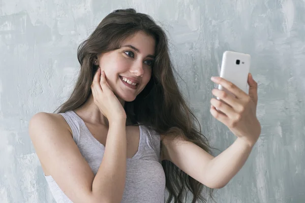 Schöne Brünette macht Selfie mit Handy — Stockfoto