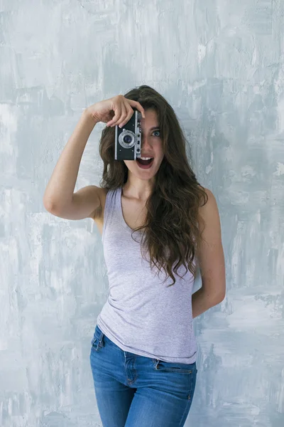 Chica sorprendida tomando fotos con cámara vintage — Foto de Stock