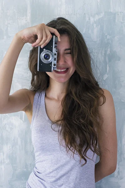 Улыбающийся брюнетка фотограф с помощью пленочной камеры, чтобы сфотографировать — стоковое фото