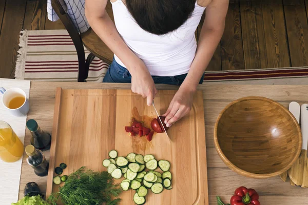 Frais généraux de la femme au foyer coupant des légumes à bord — Photo