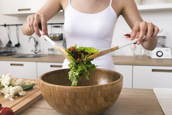 Unerkennbare Frau mixt Salat mit zwei Löffeln — Stockfoto