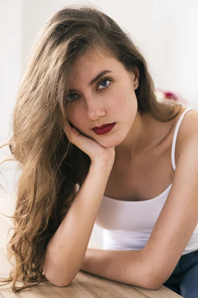 Attractive young brunette with blue eyes and red lips looking at camera — Stock Photo, Image