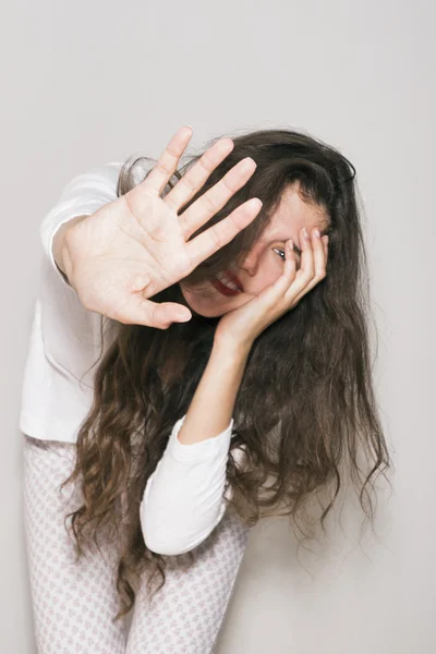Портрет сором'язливої усміхненої дівчини, що прикриває обличчя рукою Ліцензійні Стокові Фото