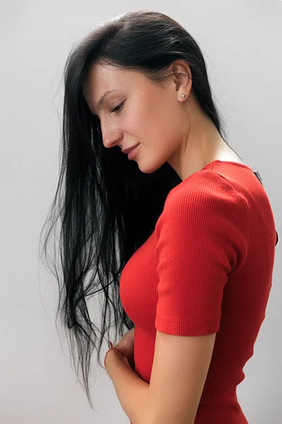 Side view of sensual woman in red with long hair looking down — Stock Photo, Image