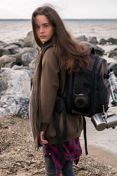 Vista lateral de chica con mochila mirando a la cámara — Foto de Stock