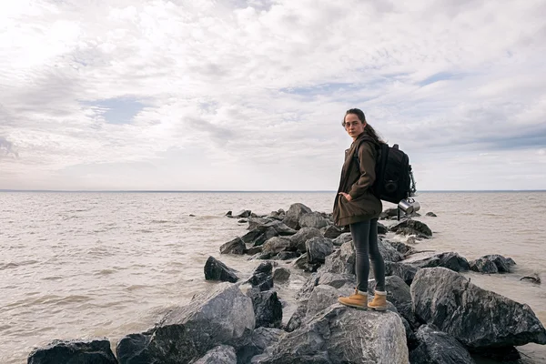 Sac à dos debout sur des rochers sur le rivage — Photo