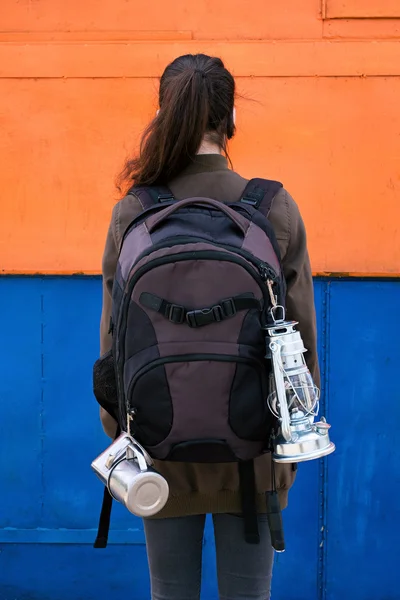 Vue arrière de la brune avec queue et sac à dos avec lanterne, tasses et lumière flash — Photo