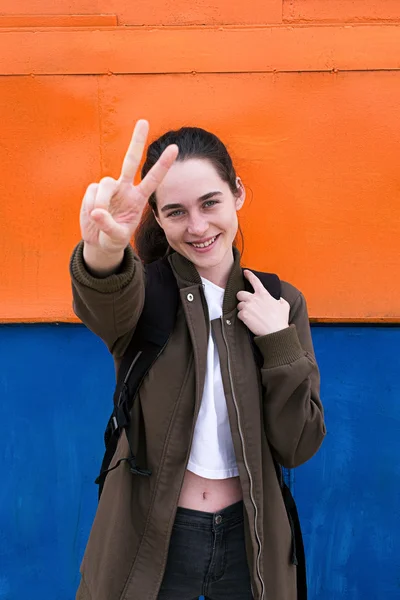 Portrait of happy backpacker showing peace sign — Stock Photo, Image