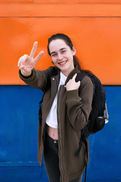 Mochileiro feliz com sinal de paz olhando para a câmera — Fotografia de Stock