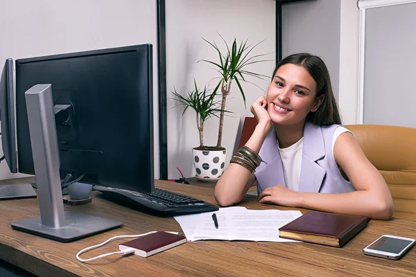Piękna kobieta interesu uśmiechający się na biurku w biurze — Zdjęcie stockowe