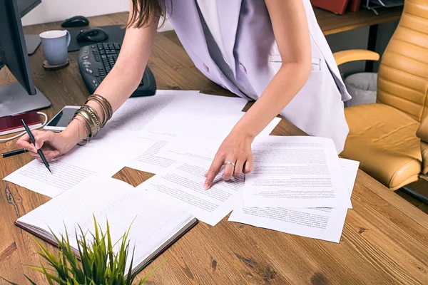 Mujer de negocios irreconocible con documentos sobre la mesa —  Fotos de Stock