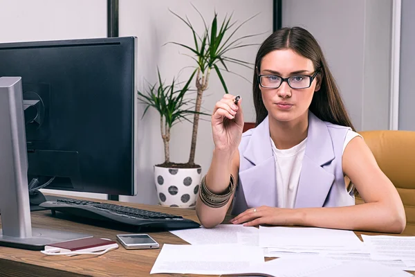 Mujer de negocios serio apuntando a la cámara con la pluma — Foto de Stock