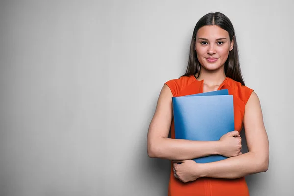 Sorridente donna d'affari che tiene cartella con due mani Foto Stock