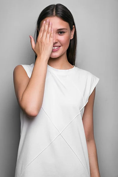 Sorrindo morena cobrindo metade do rosto com a mão Fotografia De Stock