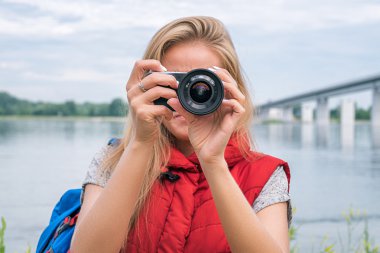 Sarışın fotoğrafçı ile yüz önünde dijital fotoğraf makinesi