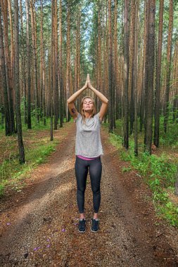 Sakin meditasyon kızla ormandaki namaste yükseltilmiş kollarında