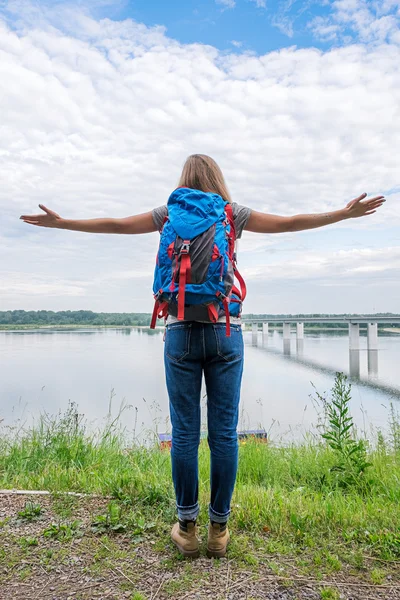 Widok do poznania backpacker z wyciągniętą bronią przeciwko rzeki z tyłu — Zdjęcie stockowe