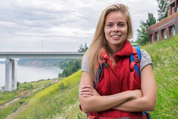 Menina bonita com mochila contra de paisagem — Fotografia de Stock