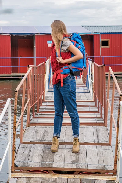 Αγνώριστη γυναίκα backpacker κοιτάζοντας πίσω στη γέφυρα — Φωτογραφία Αρχείου