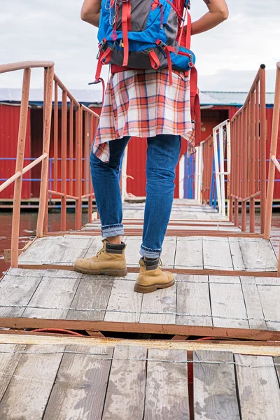 Vista posteriore di zaino in spalla irriconoscibile in piedi sul ponte che porta alla costruzione — Foto Stock