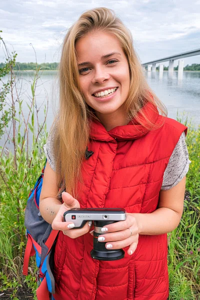 Vrolijke blonde backpacker met digitale camera — Stockfoto