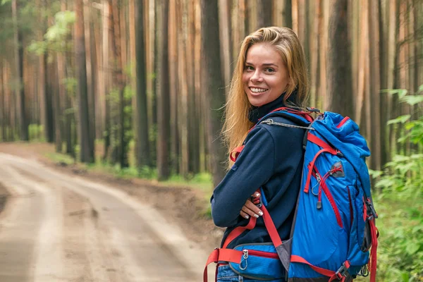 Felice bella ragazza con lo zaino nella foresta — Foto Stock