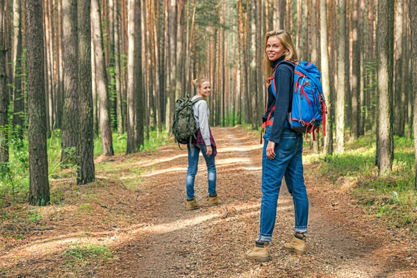 숲에서 배낭과 두 명의 행복 한 여자 스톡 이미지