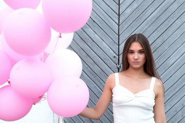 Ciddi esmer kameraya pembe balon ile bakmanın portre