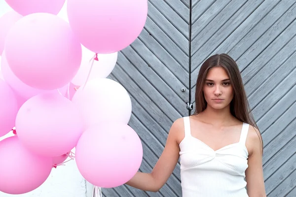 Ciddi esmer kameraya pembe balon ile bakmanın portre