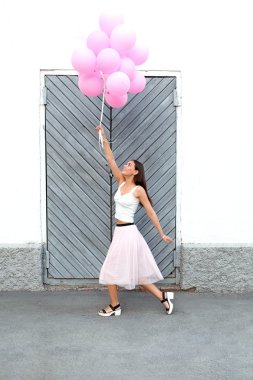 Pembe balonlar içinde hareket sokakta uçan ile esmer kız yan görünüm