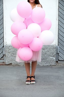Güzel pembe ve beyaz hava balonları sokakta tanınmaz halde genç kız tarafından tutulan Close-Up