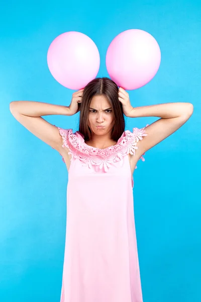 Portret Zły Brunetka Różowej Sukience Miny Gospodarstwa Dwa Balony Głowie — Zdjęcie stockowe