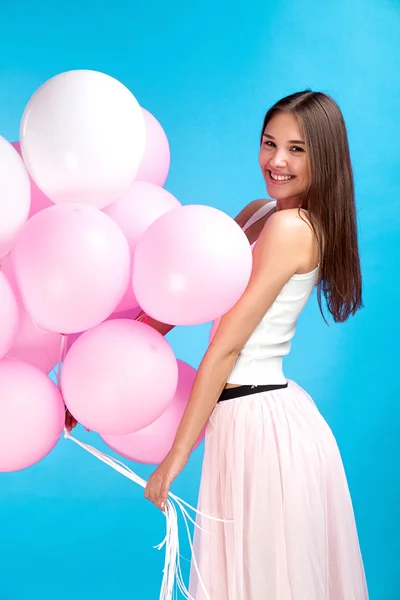 有吸引力的年轻女孩的侧视图与空气气球微笑在照相机 — 图库照片