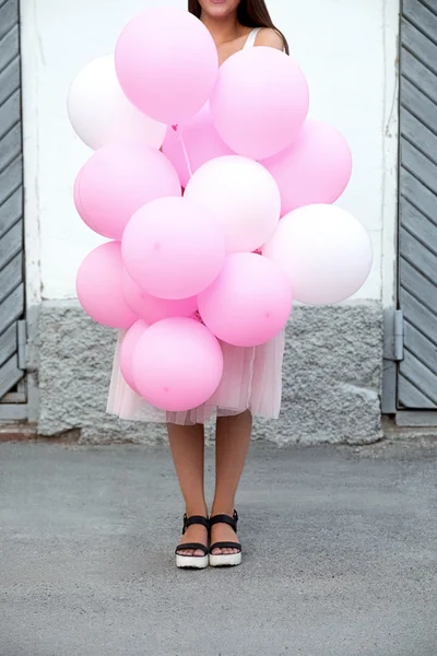 Güzel pembe ve beyaz hava balonları sokakta tanınmaz halde genç kız tarafından tutulan Close-Up