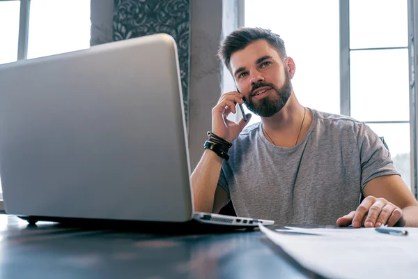 Portret Van Knappe Glimlachende Man Praten Smartphone Bureau Met Laptop — Stockfoto