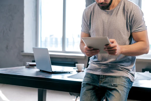 Unerkennbarer Bärtiger Mann Lehnt Auf Tisch Und Benutzt Unterlage — Stockfoto