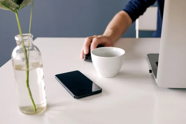 Unrecognizable Man Using Laptop Mouse Table Vase Smartphone Cup Daylight — Stock Photo, Image