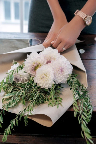 Närbild Oigenkännlig Florist Inslagning Bukett Cypress Och Krysantemum Kraftpapper Bord Stockbild