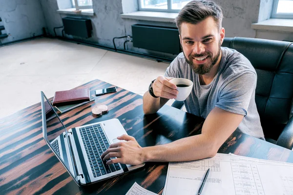 Portrét Veselého Podnikatele Který Pije Kávu Používá Notebook Kanceláři — Stock fotografie