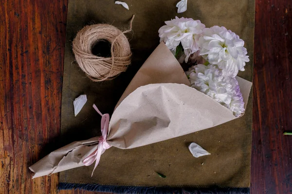 Vista Superior Flores Blancas Envueltas Papel Artesanal Sobre Mesa Madera — Foto de Stock