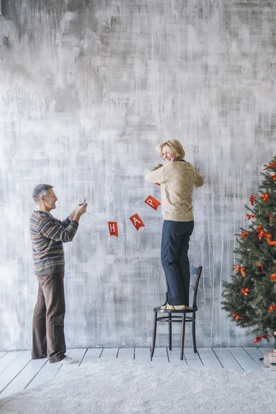 Elderly couple decorating the wall — Stock Photo, Image
