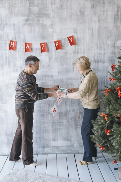 Два пожилых человека украшают дом — стоковое фото