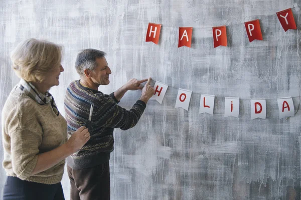 Pareja de personas mayores decorando la pared — Foto de Stock