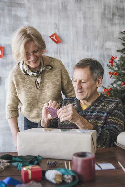 Zwei ältere Menschen dekorieren die Geschenkbox — Stockfoto